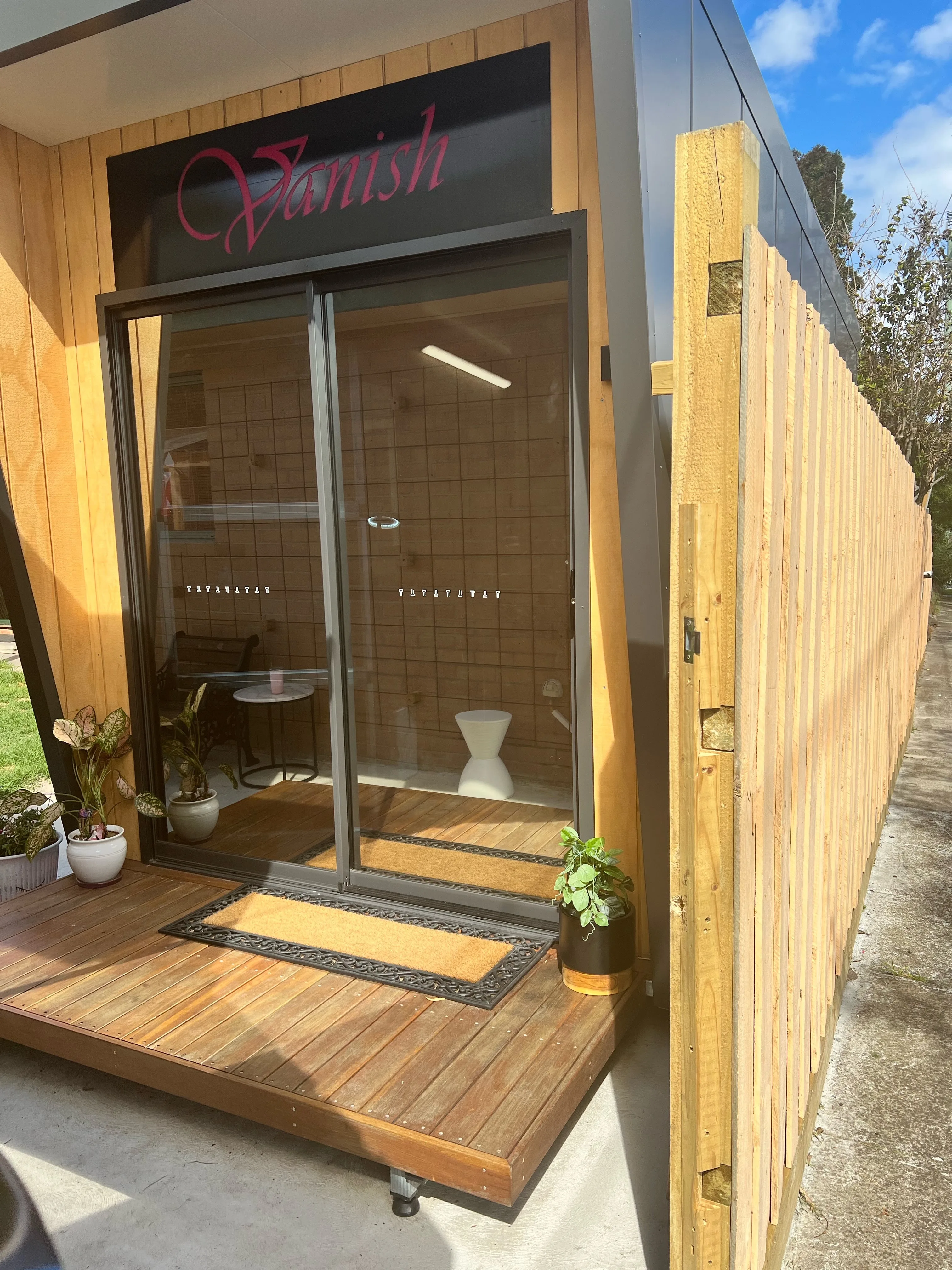 Vanish studio glass entrance under the black Vanish fascia sign on the deck